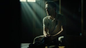 England cricketer Chris Woakes sitting in locker room looking thoughtfully at his cricket cap after retirement announcement